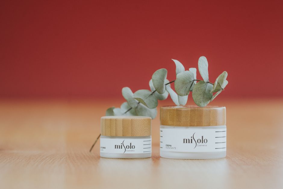 Elegant display of skincare products with eucalyptus on a wooden surface, ideal for natural beauty themes.